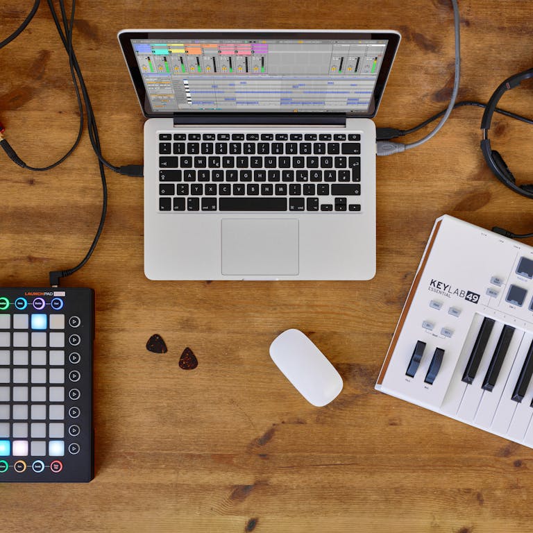 Live 12 Lite on a laptop, grid controller and MIDI keyboard on table